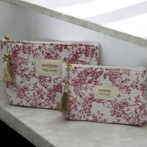 Trousse et pochette en coton motif floral délicat en bordeaux sur un fond blanc